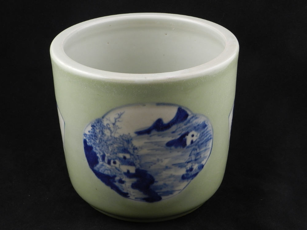 A Chinese porcelain Jardinere decorated with landscape panels on a celedon ground