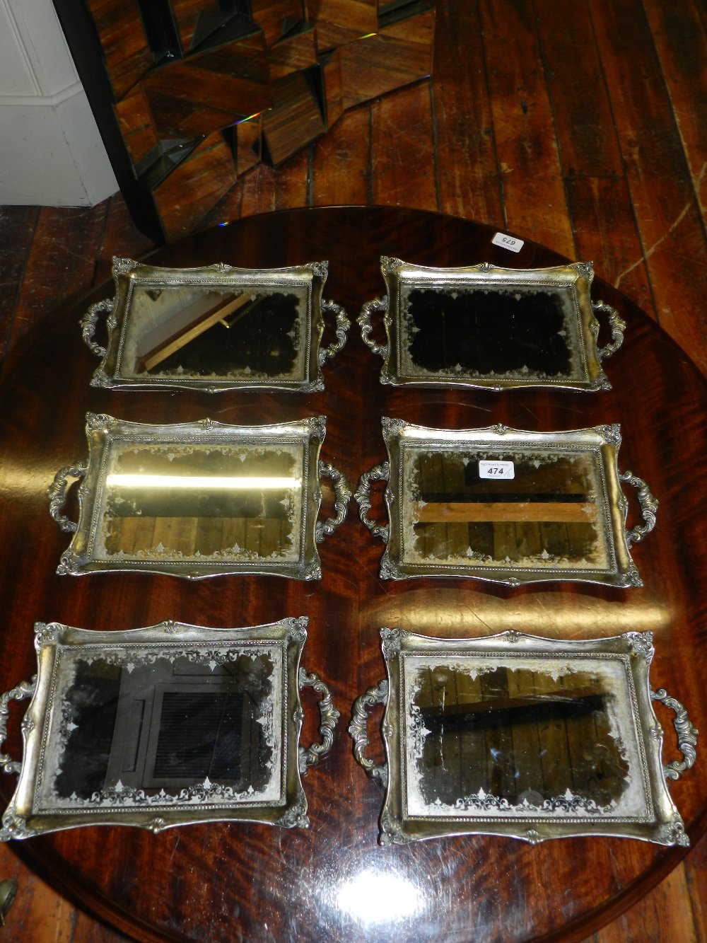 A set of six silvered twin handle serving trays inset with mirrored panels.