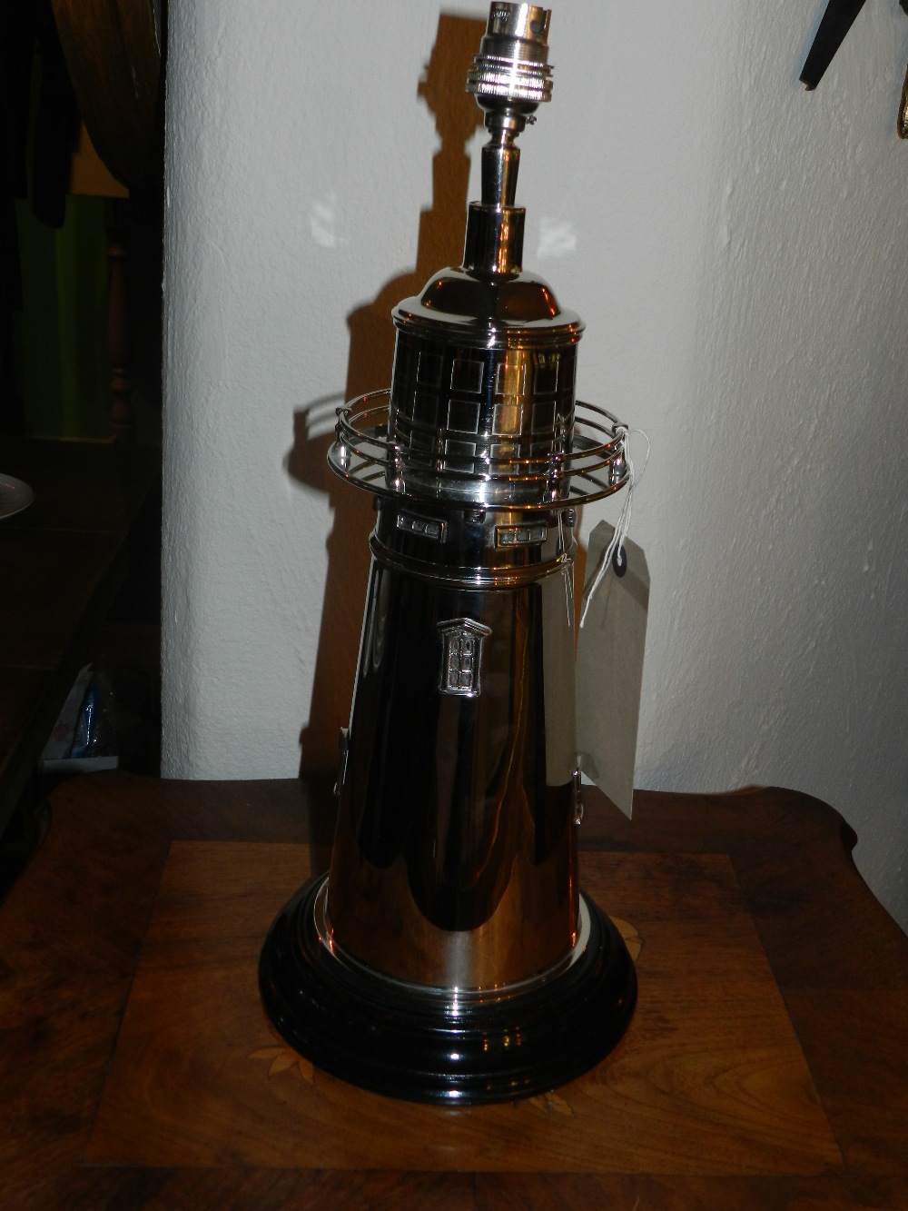 A silver plated lamp base in the form of a light house.