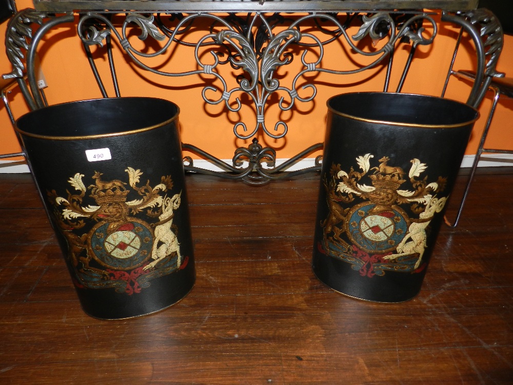 A pair of tole ware waste paper baskets decorated with a coat of arms.