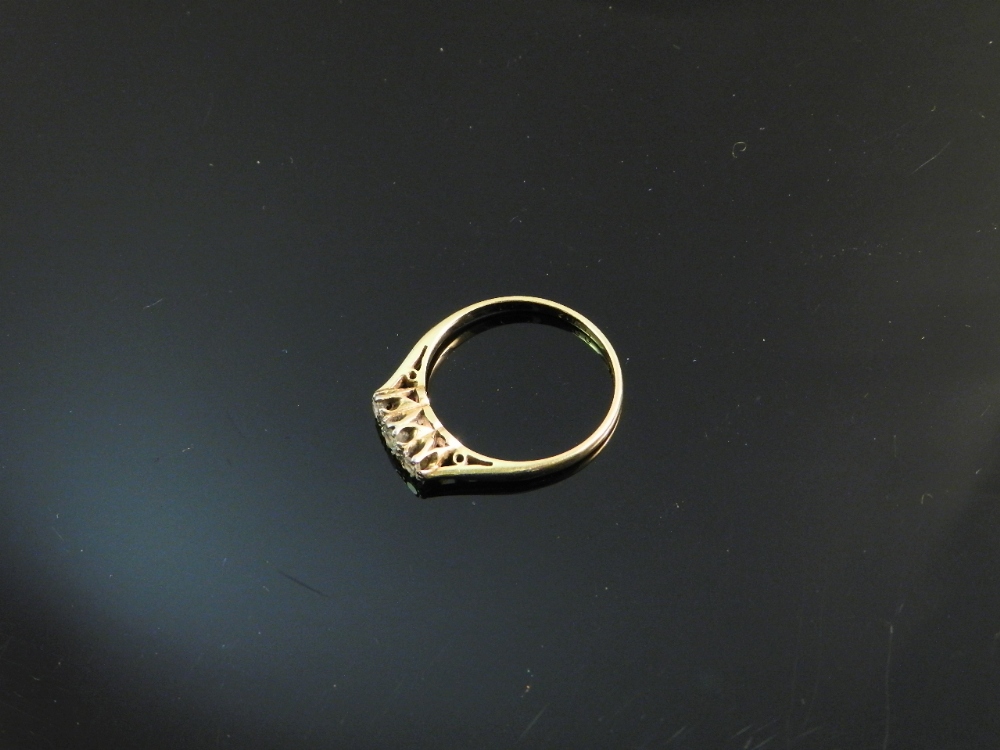 An 18ct gold three stone ring. Approx 0.30ct diamonds. With case.