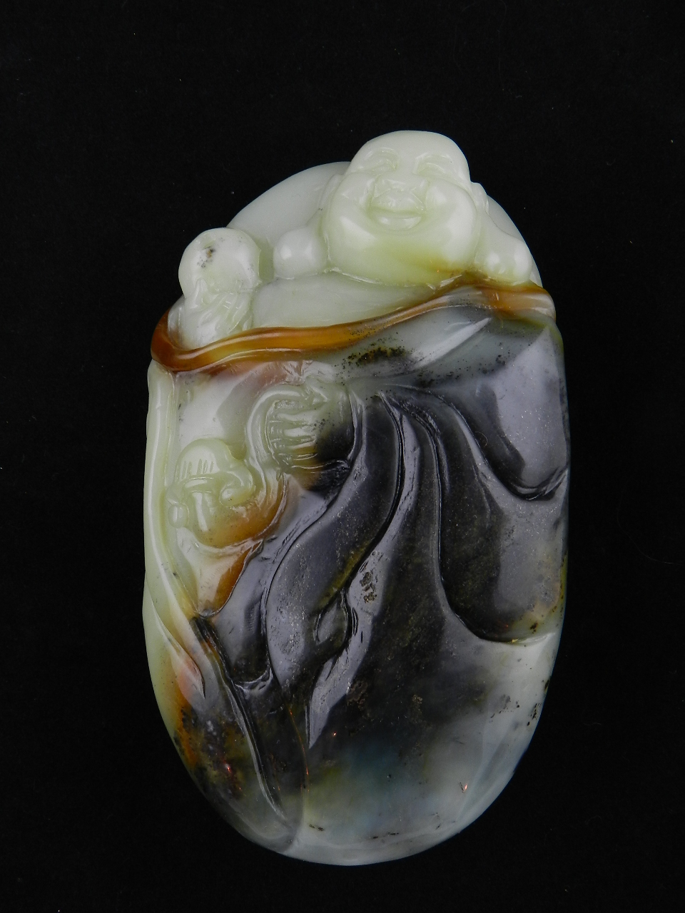 An oriental paperweight in the form of a happy Buddha