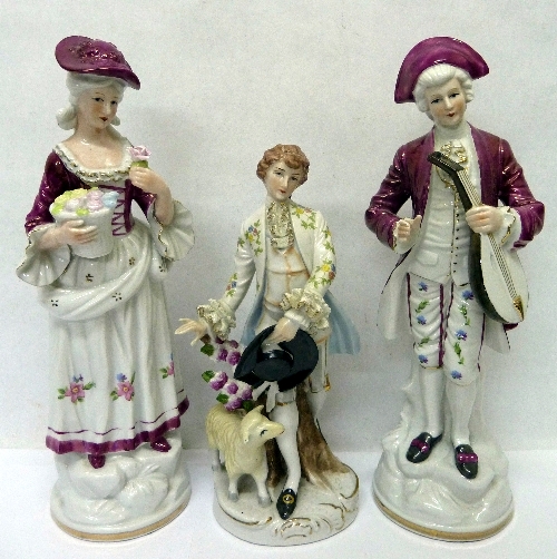 A pair of continental figures and one other figure, height of pair 33cms