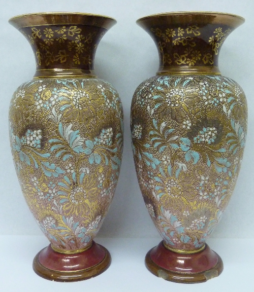 A pair of Doulton Lambeth Slater`s Patent stoneware vases with floral decoration on a textured