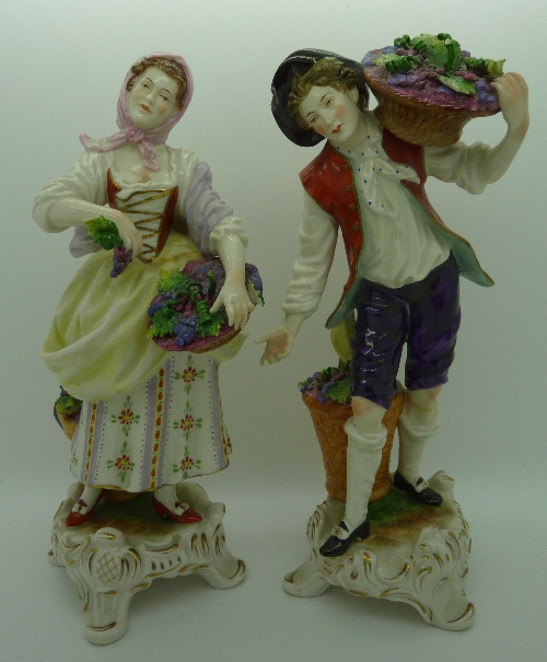 A pair of German porcelain figures of grape pickers, impressed numbers 379 and 380 to bases,