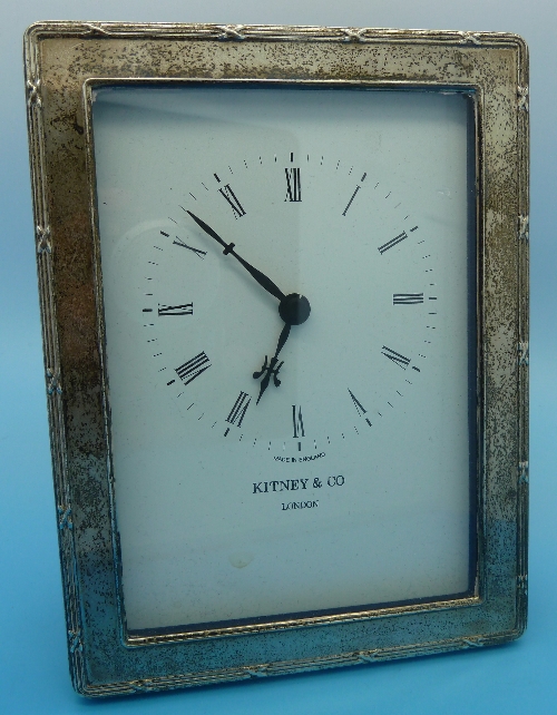 A modern silver fronted quartz clock, height 15.5cms
