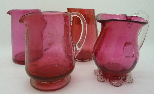 Four cranberry glass jugs, one a/f, height of tallest 9cms