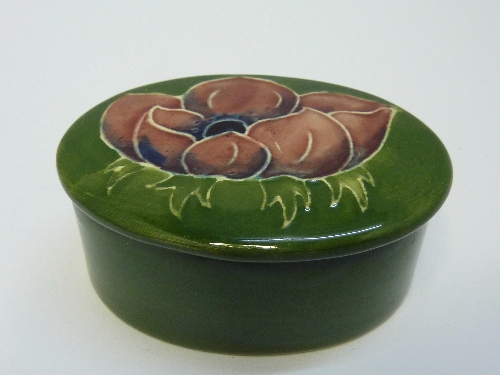 A Moorcroft box and cover decorated in the anemone pattern on a green ground, height 3.5cms, width