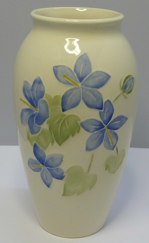 A Moorcroft vase decorated with tube lined flowers on a cream ground, height 19cms