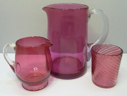 A cranberry glass tumbler, a/f and two jugs, height of tallest 15.5cms