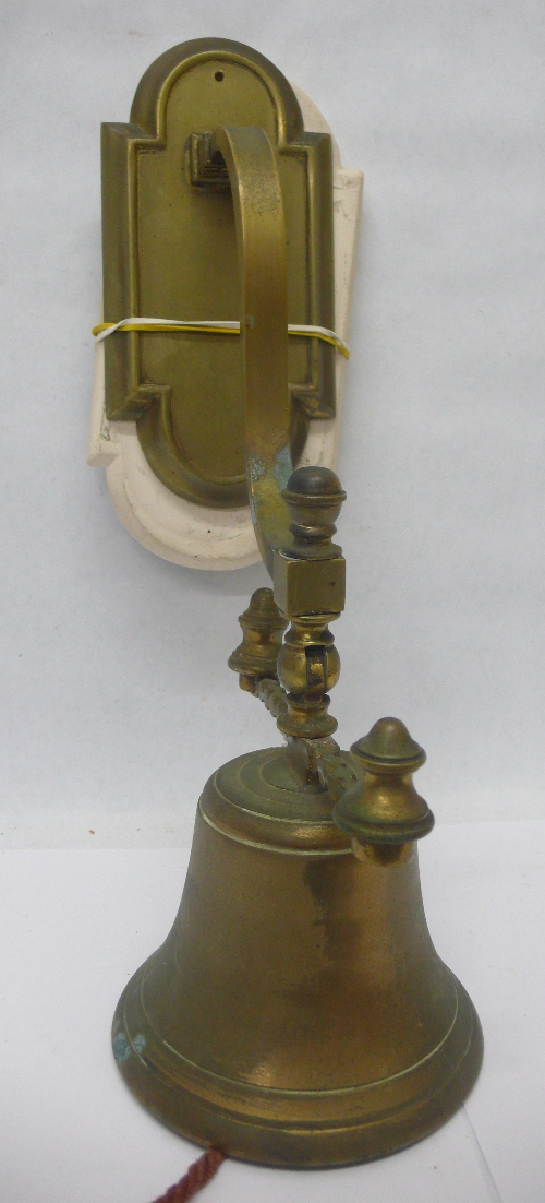 A brass door bell and wall mount