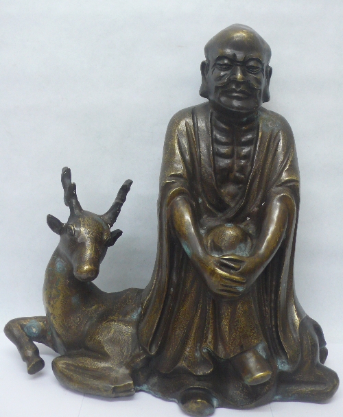A Chinese bronze figure of a Sage seated upon the back of a deer, height 38cms