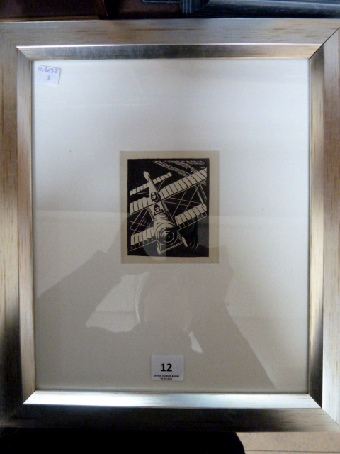 A lithograph of a bi-plane by Gill Dyer, framed