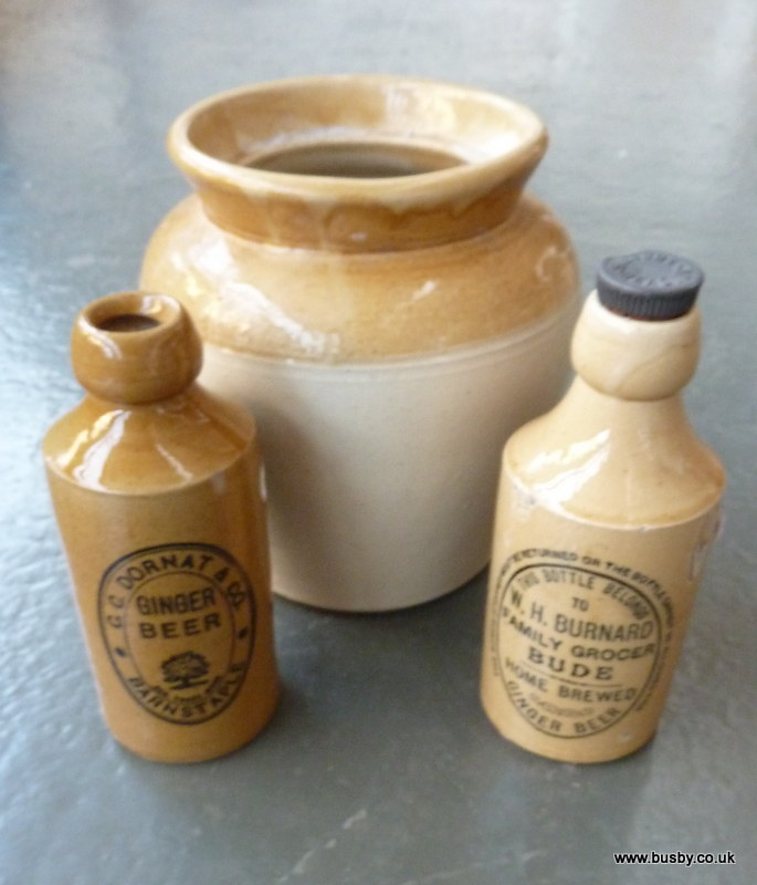 Two ceramic ginger beer bottles; one marked W H Burnard Family Grocer Bude Home Brewed Ginger