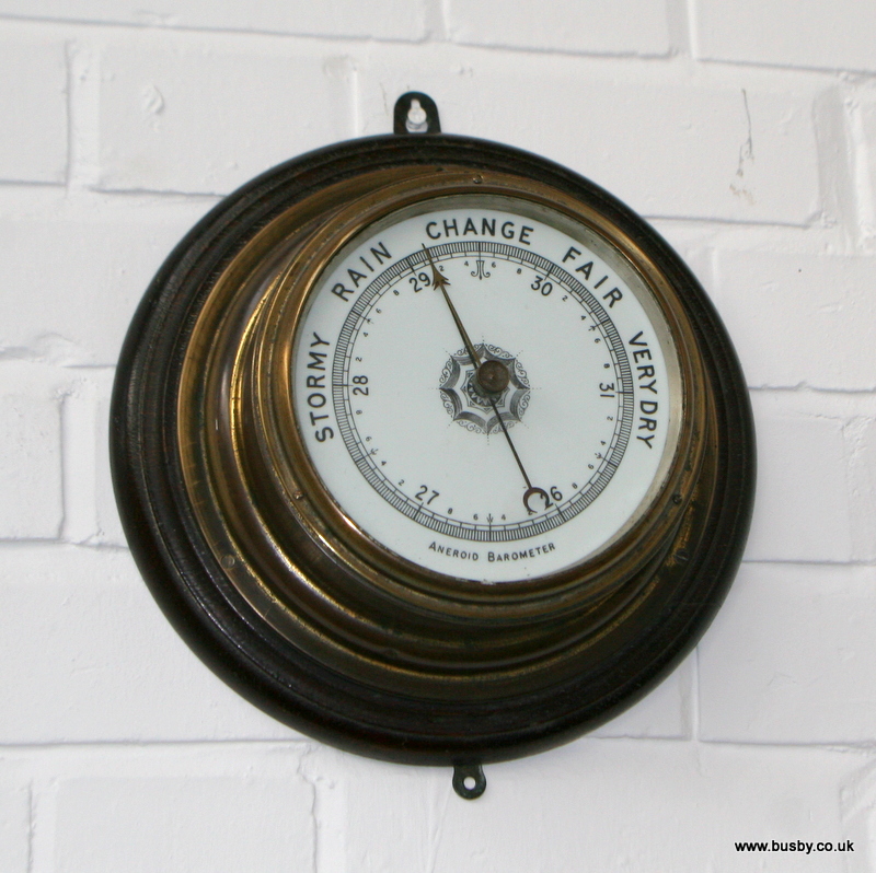 A beech surround wall mounted diaphragm barometer 11in(28cm)dia.