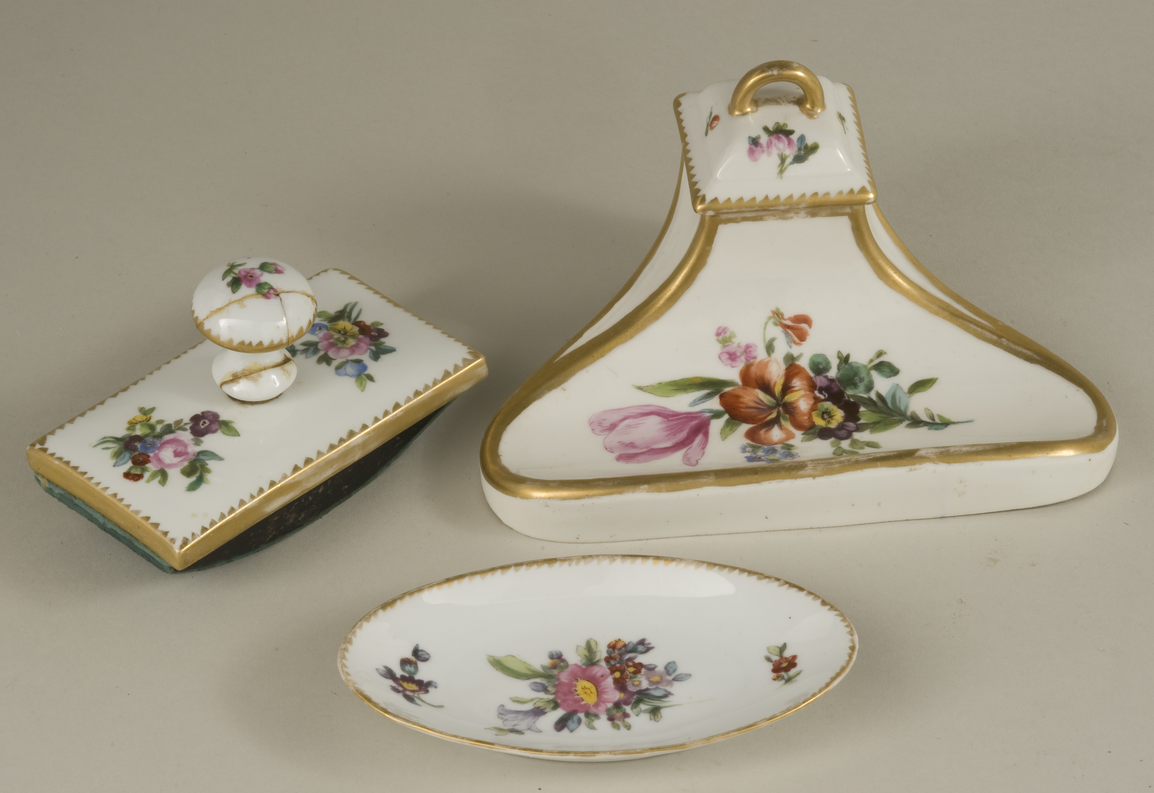 A 1919 Silesian Chine porcelain desk set with hand painted floral reserves, comprising an inkwell