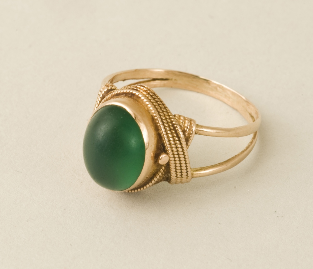 A vintage lady’s 14ct bezel set cabochon cut green onyx ring with ropework decoration. Size M (U.