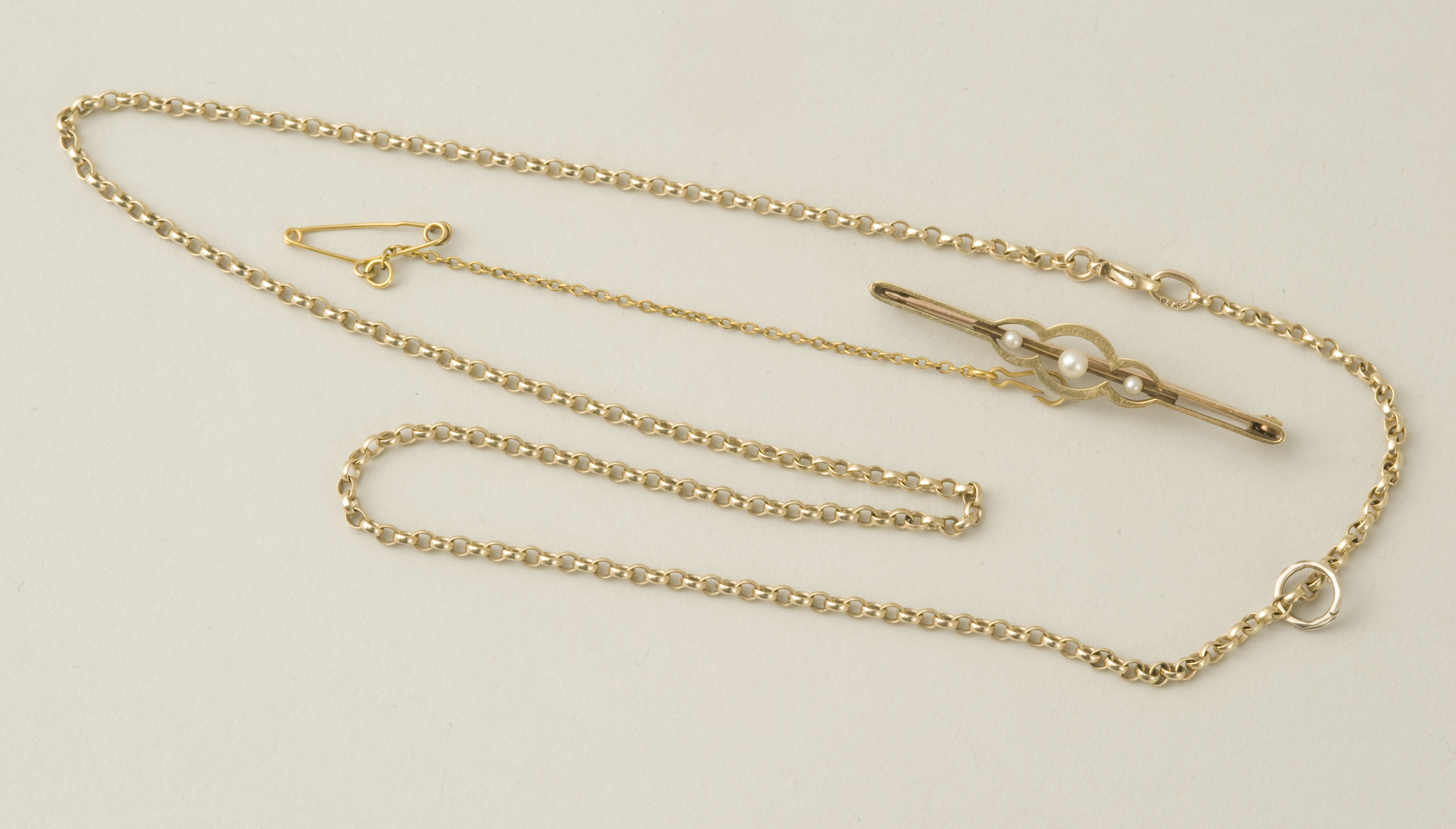 A vintage 15ct gold three seed pearl bar brooch with safety chain 2.9g; together with a 9ct gold