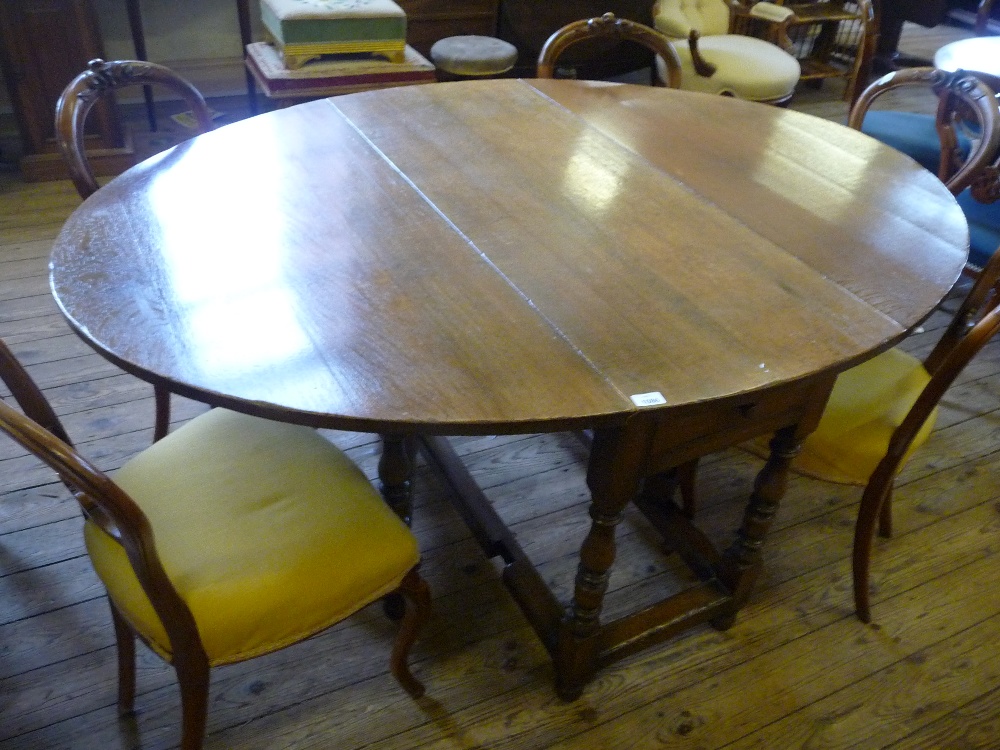 An Oak oval flap leaf table with single drawer and turned supports, W. 18 1/2", ext. W. 65" and H.