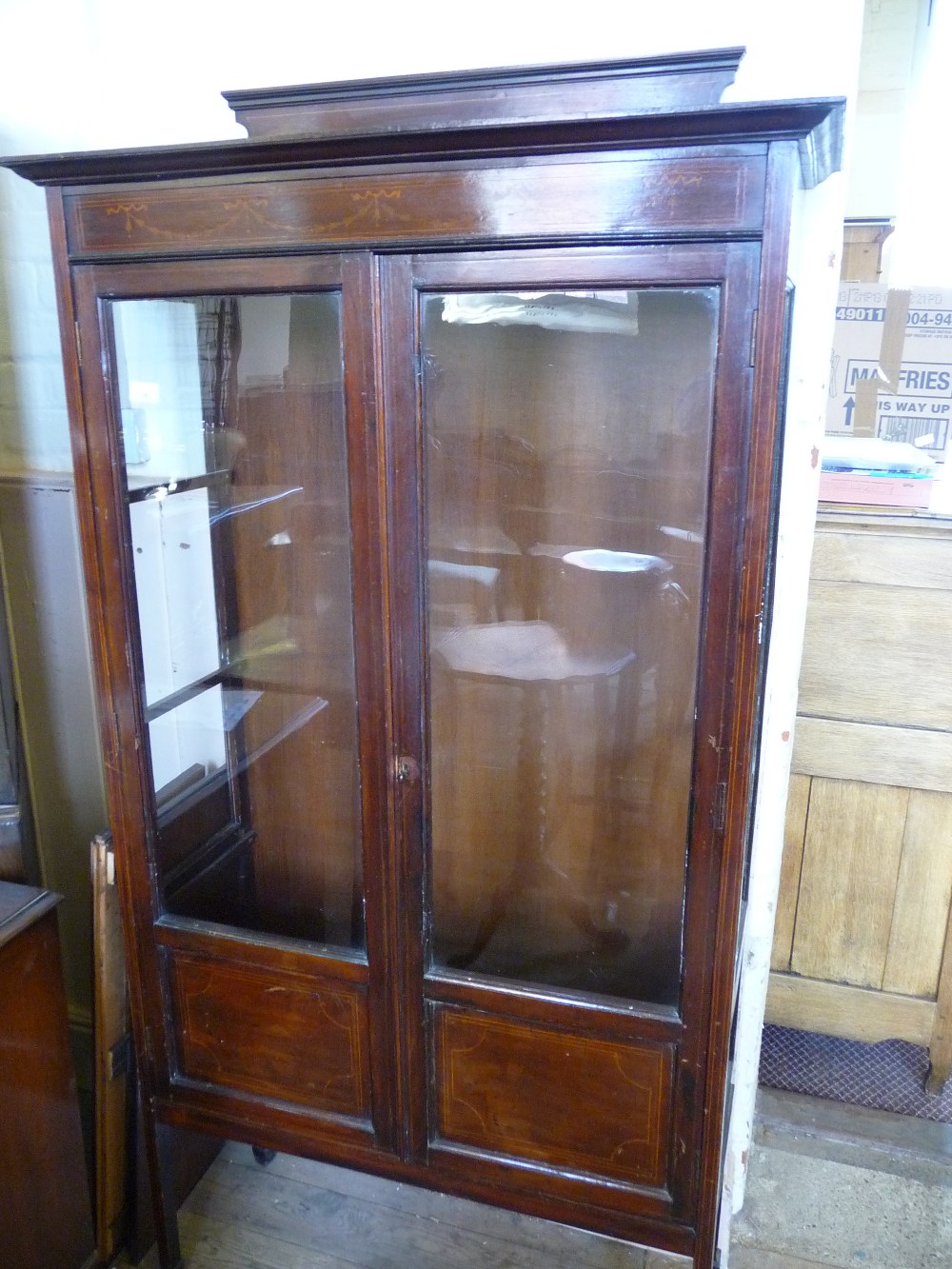 An Edwardian inlaid display cabinet, a small Oak table, profusely carved with leaves and a bedside