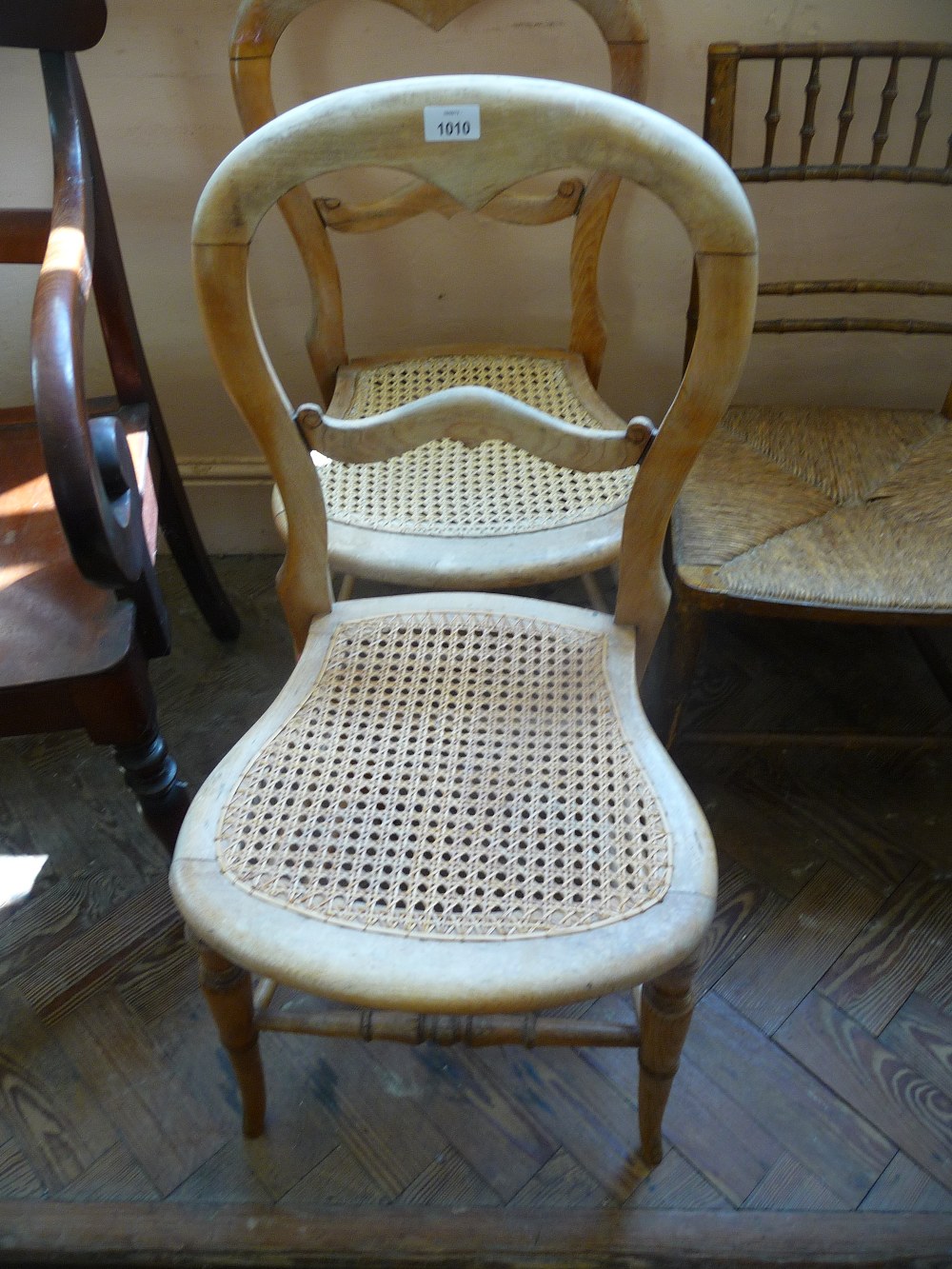 Three caned seated side chairs (two stripped).