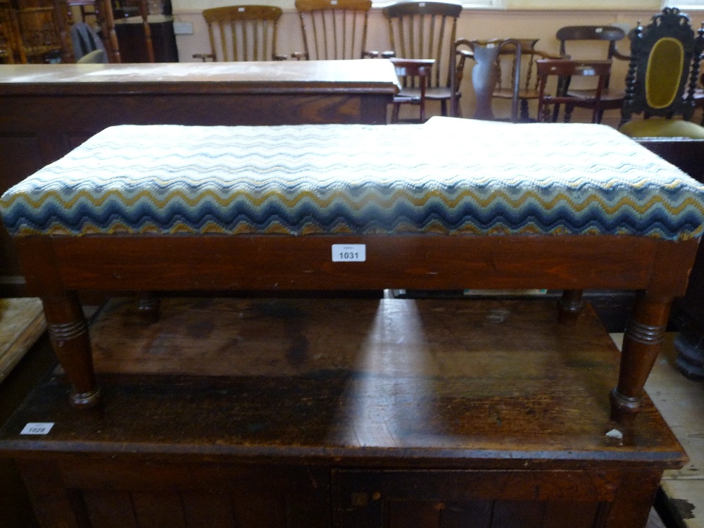 A small round coffee table and a low upholstered stool.