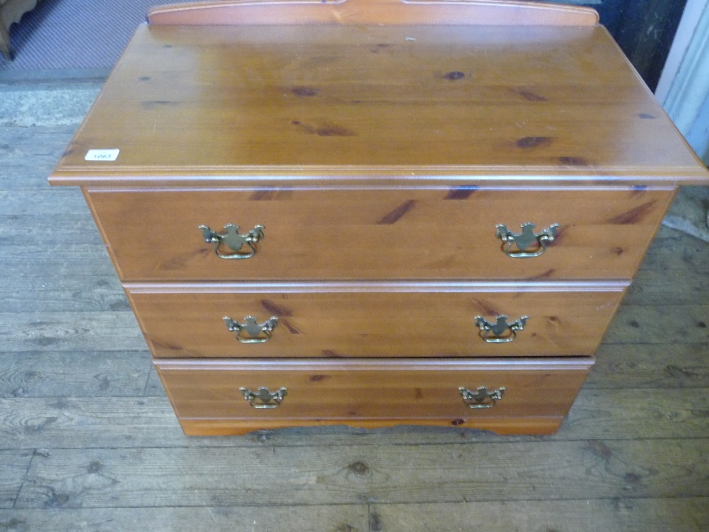 A Pine chest of three drawers having a Pine top and drawer fronts, sides veneered.