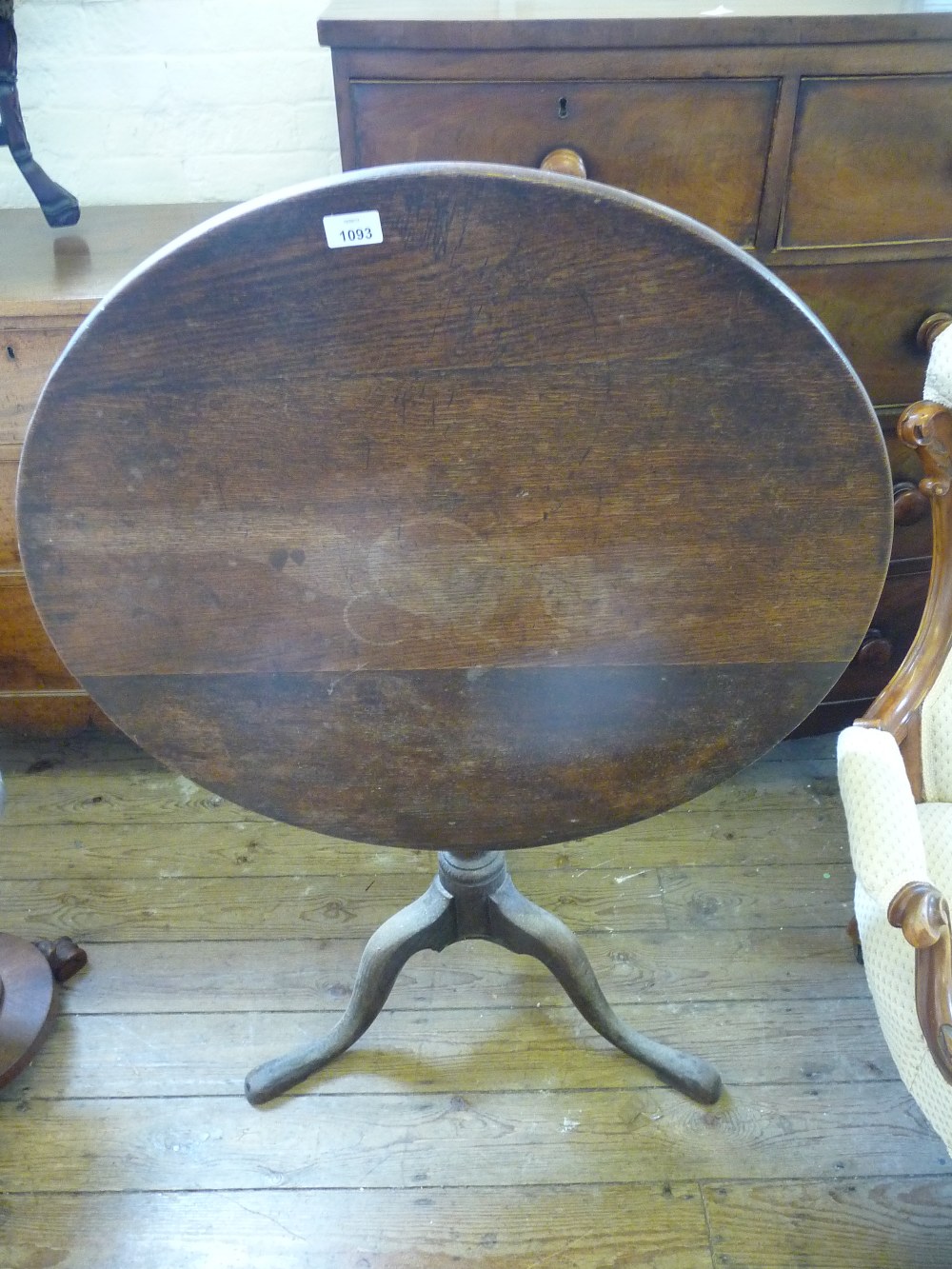 An Oak circular tilt top tripod table, Dia. 30" and H. 28 1/2".