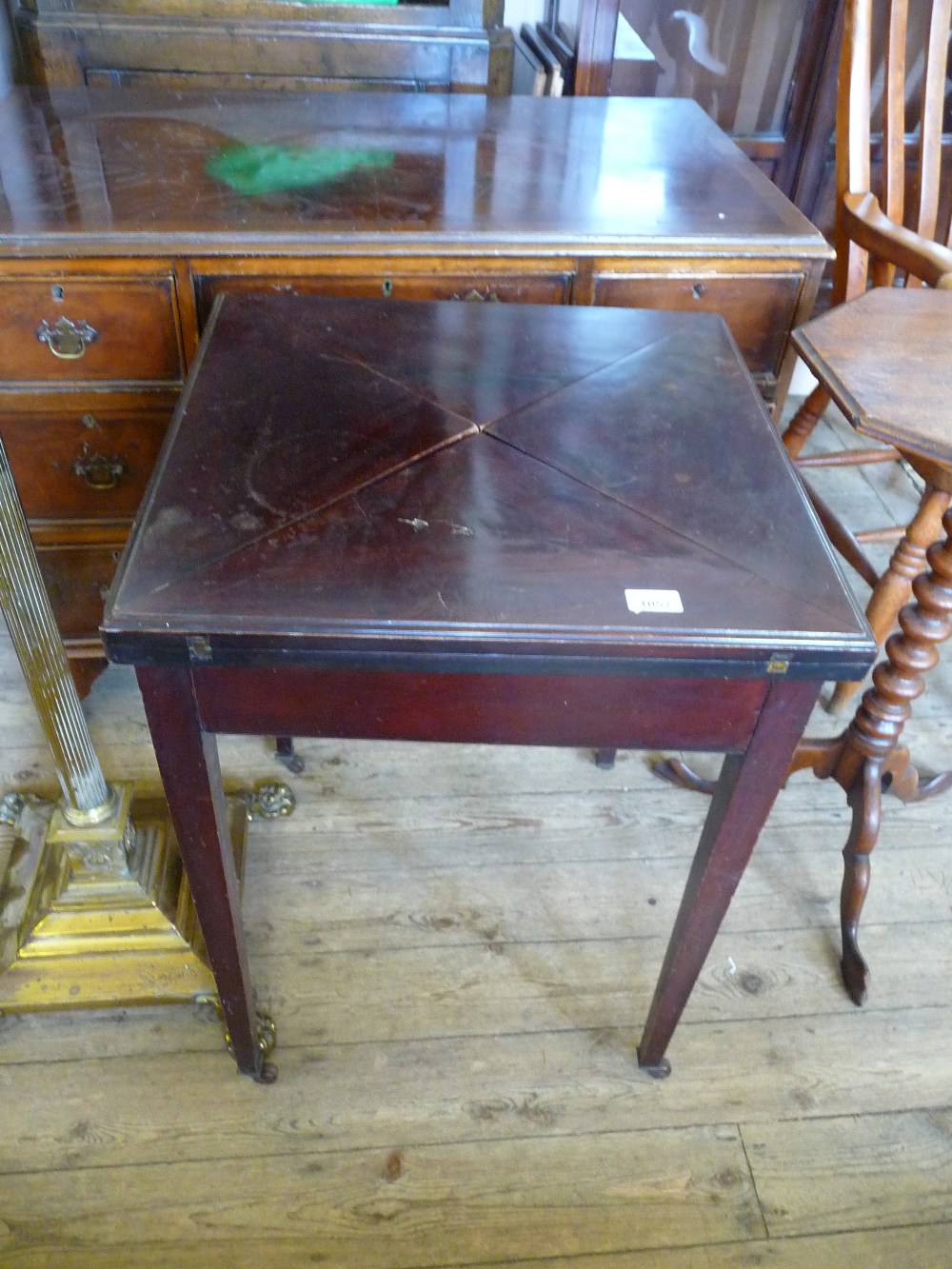 A Mahogany envelope card table with single drawer (as found).