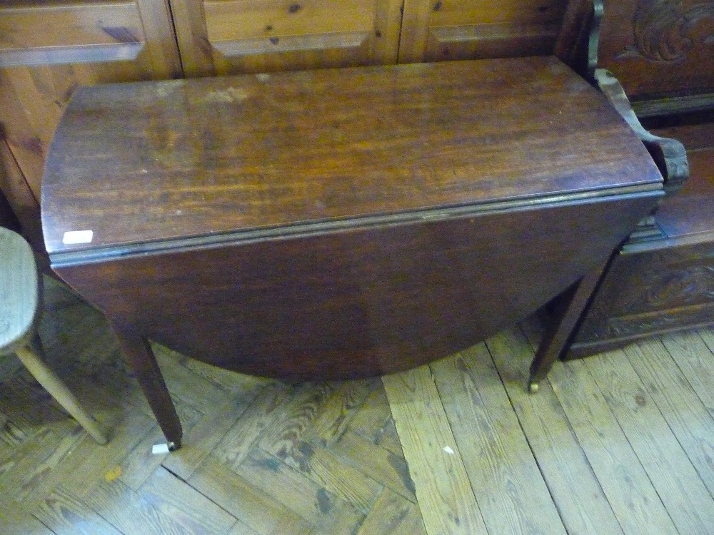 An Oak flap leaf table on Brass castors.