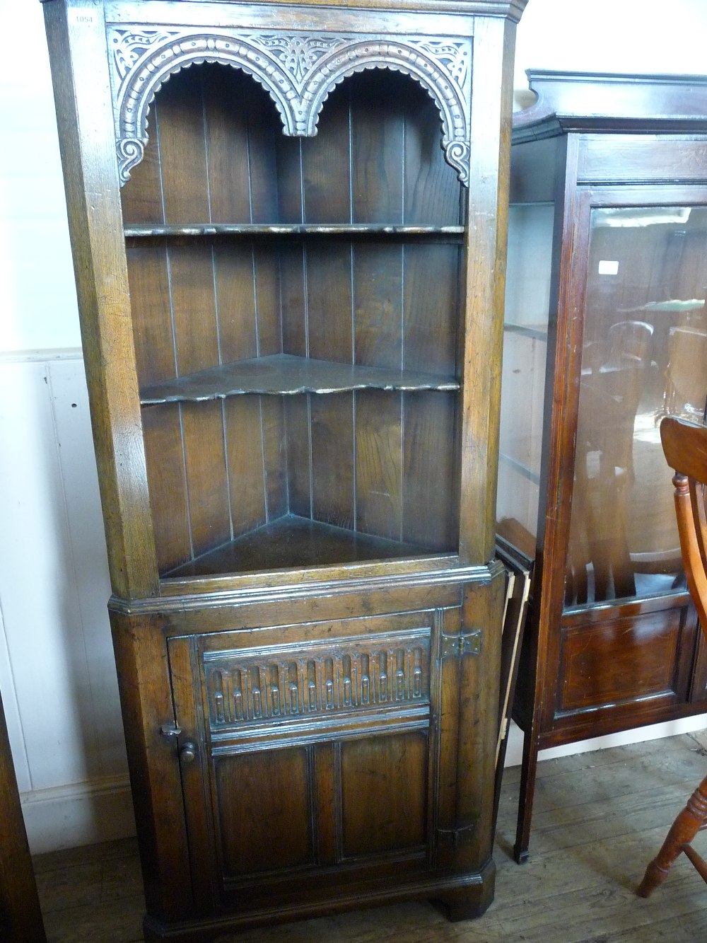 A carved Oak corner cabinet with single cupboard D. 20", W. 28" and H. 70 1/2".