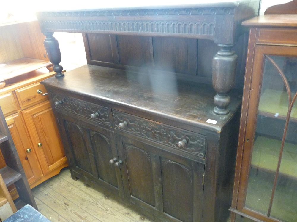 A carved Oak two door court cupboard, retailed by Robertson and Coleman, Norwich, D. 17", W. 49" and