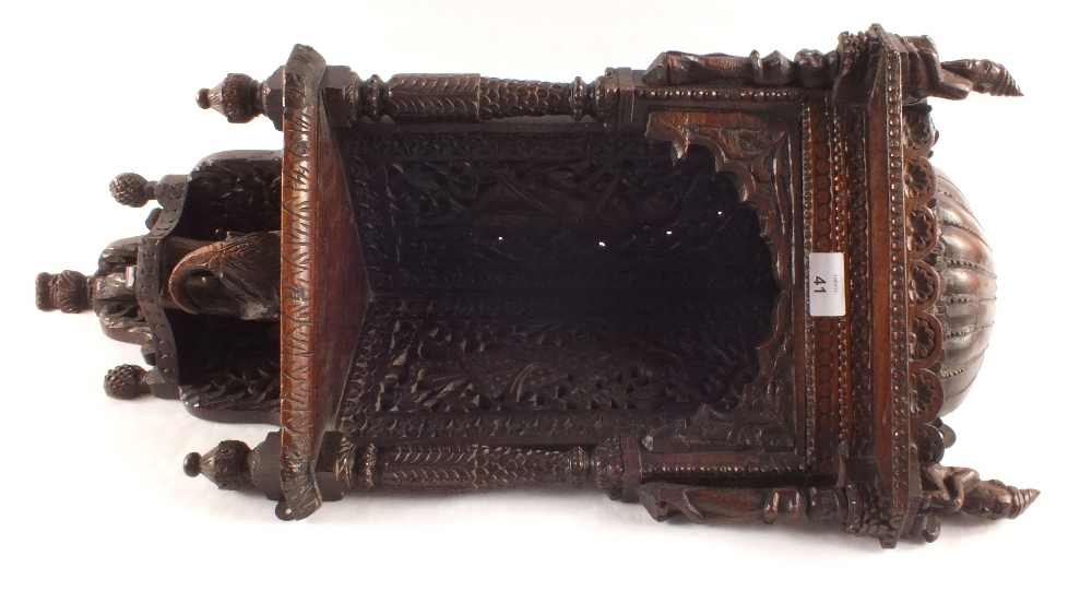 An ornate Indian carved hardwood wall shelf with figure and elephant decoration