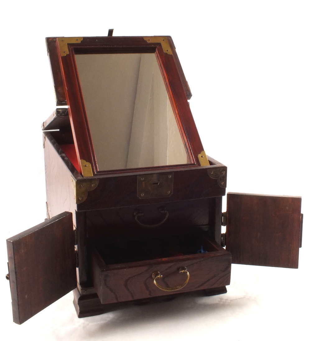 A Chinese two drawer miniature chest with rising top enclosing a folding mirror