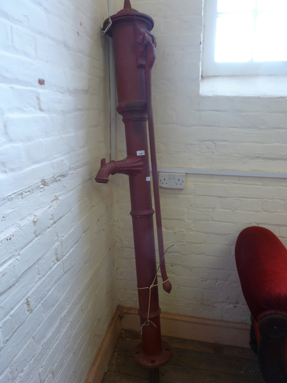 A Victorian cast iron water pump, painted red