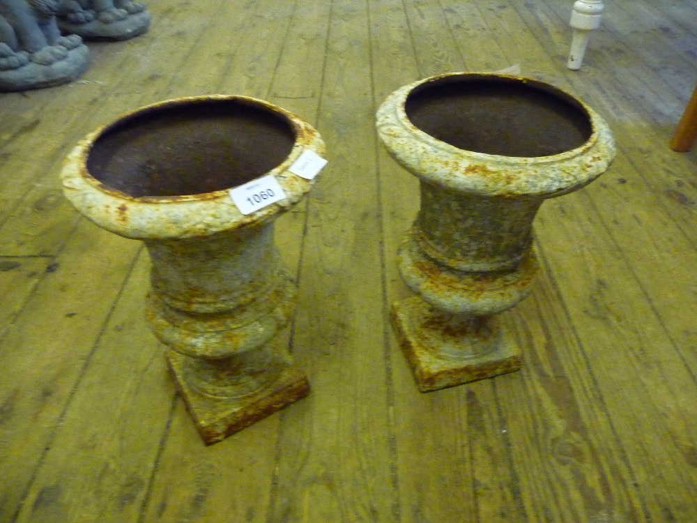 Two small cast iron garden urns