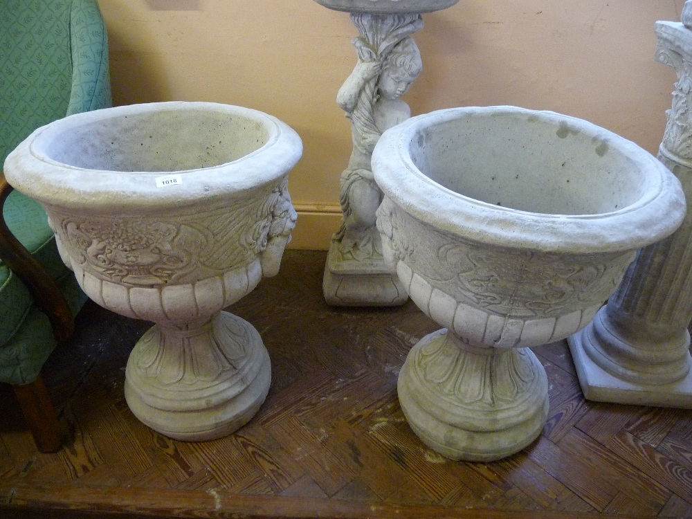 Two large concrete lion masked garden urns