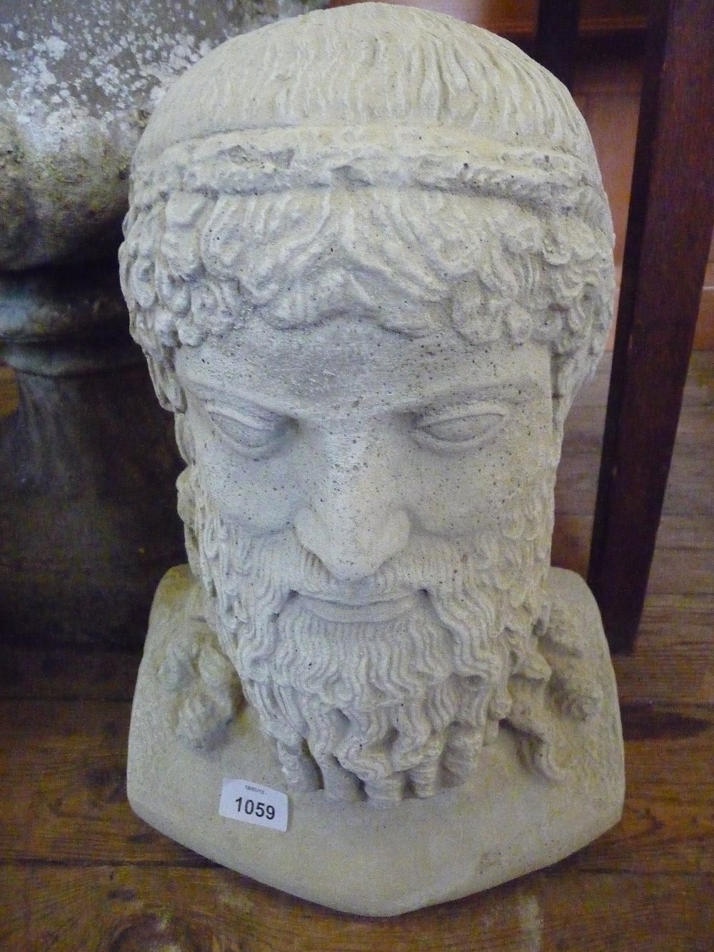 A concrete bust of a Greek god