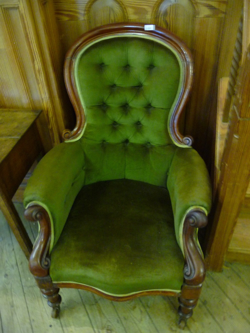 A Victorian green upholstered button back armchair