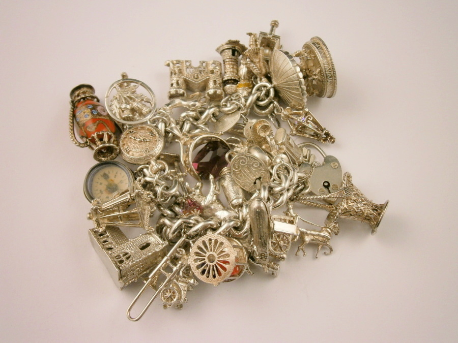 A silver charm bracelet, with approx. 33 charms, charms are unmarked, 181.8g all in