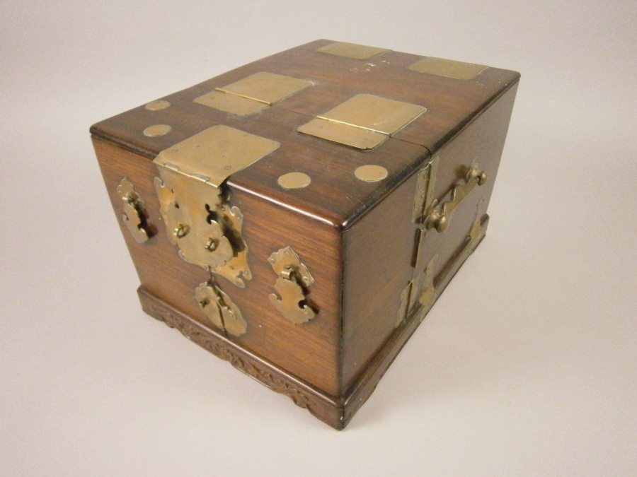 A late 19th/early 20thC Chinese hardwood and brass bound dressing case, the hinged lid enclosing