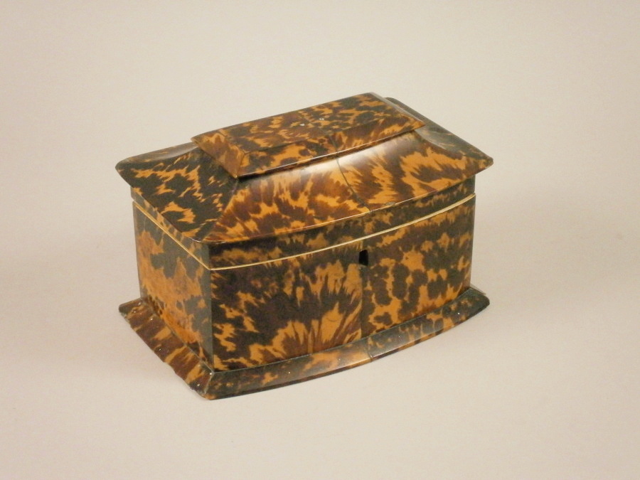 A mid 19thC tortoise-shell tea caddy, the hinged lid enclosing a later velvet lined interior, on a