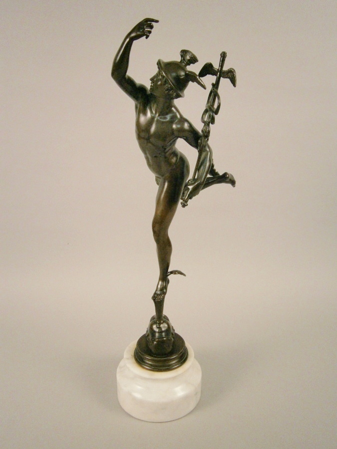 After Giambologna. A bronze figure of Mercury, standing on a white marble plinth, 63cm high