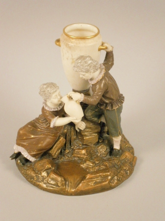 A Royal Worcester porcelain blush ivory ground figure group, of a young boy and lady with a water