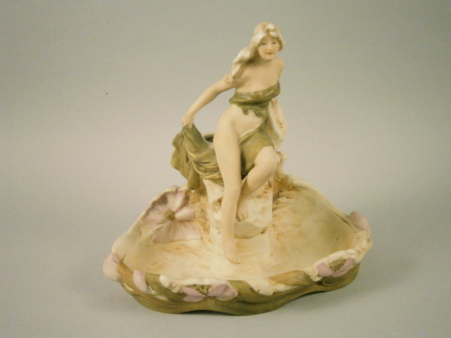 A late 19th/early 20thC Royal Dux porcelain centre piece, mounted with a scantily clad lady in Art