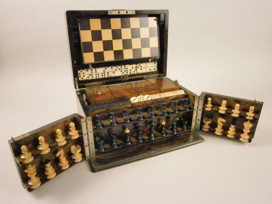 A Victorian games compendium, in a walnut case, the hinged lid enclosing a turned wooden chess