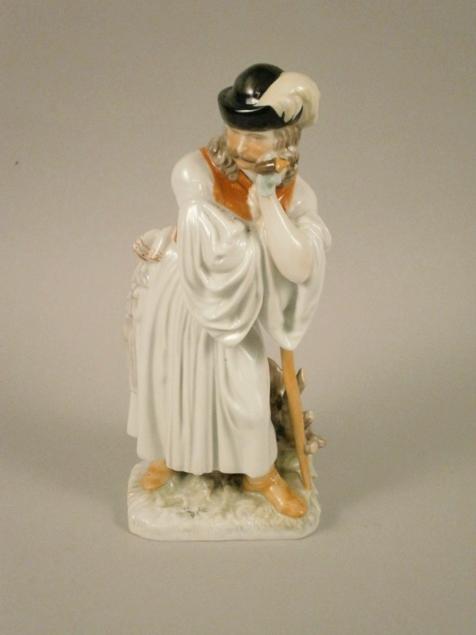 A Herend porcelain figure of a gentleman with a moustache and pipe, wearing a dress, holding a