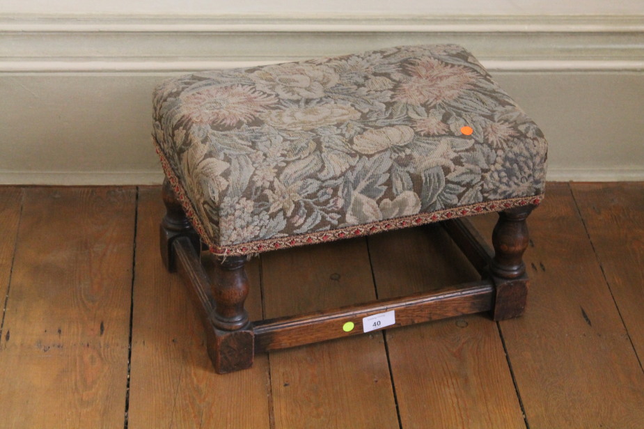 A small oak joint stool with floral tapestry upholstery, 40cm x 28cm.