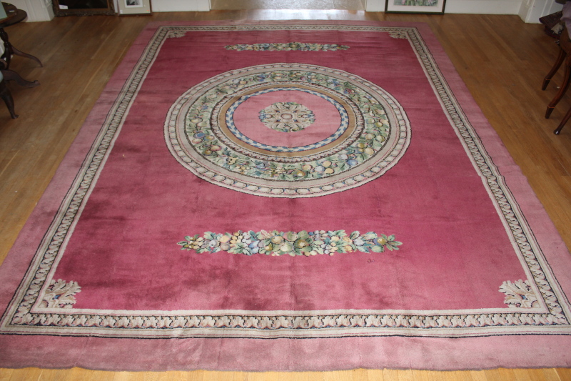 An Axminster pink ground Empire design carpet, with central foliate and fruiting bordered medallion