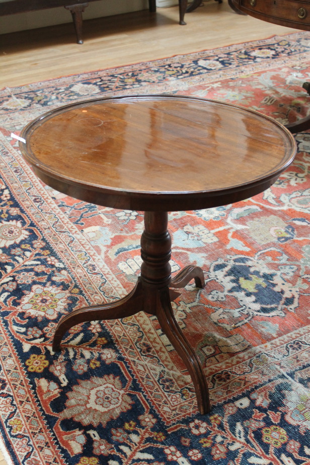 A late Georgian mahogany supper table, with moulded circular tilt top, turned pillar and three